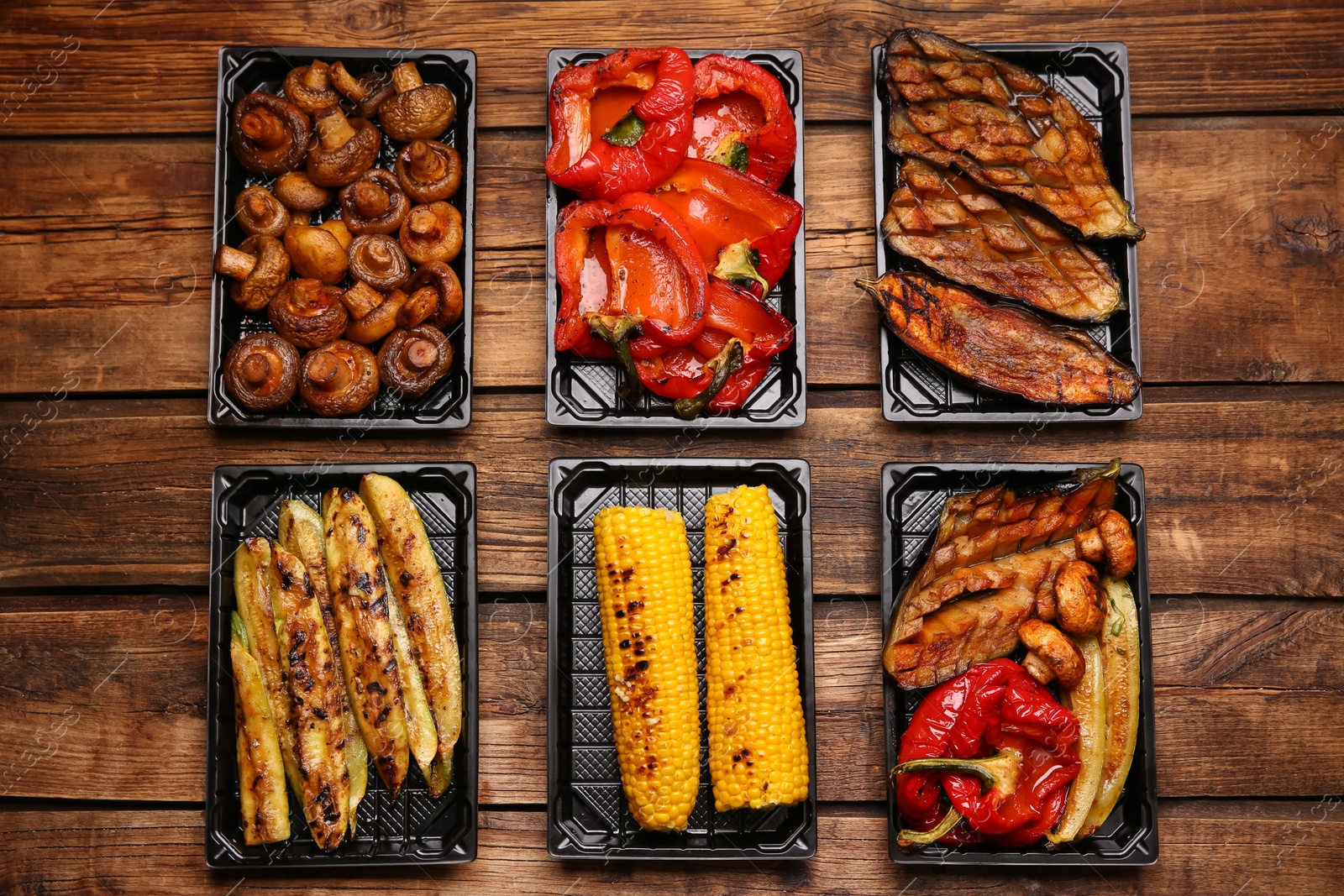 Photo of Plastic containers with different grilled meal on wooden table, flat lay. Food delivery service