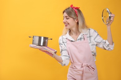 Photo of Young housewife with pot on yellow background