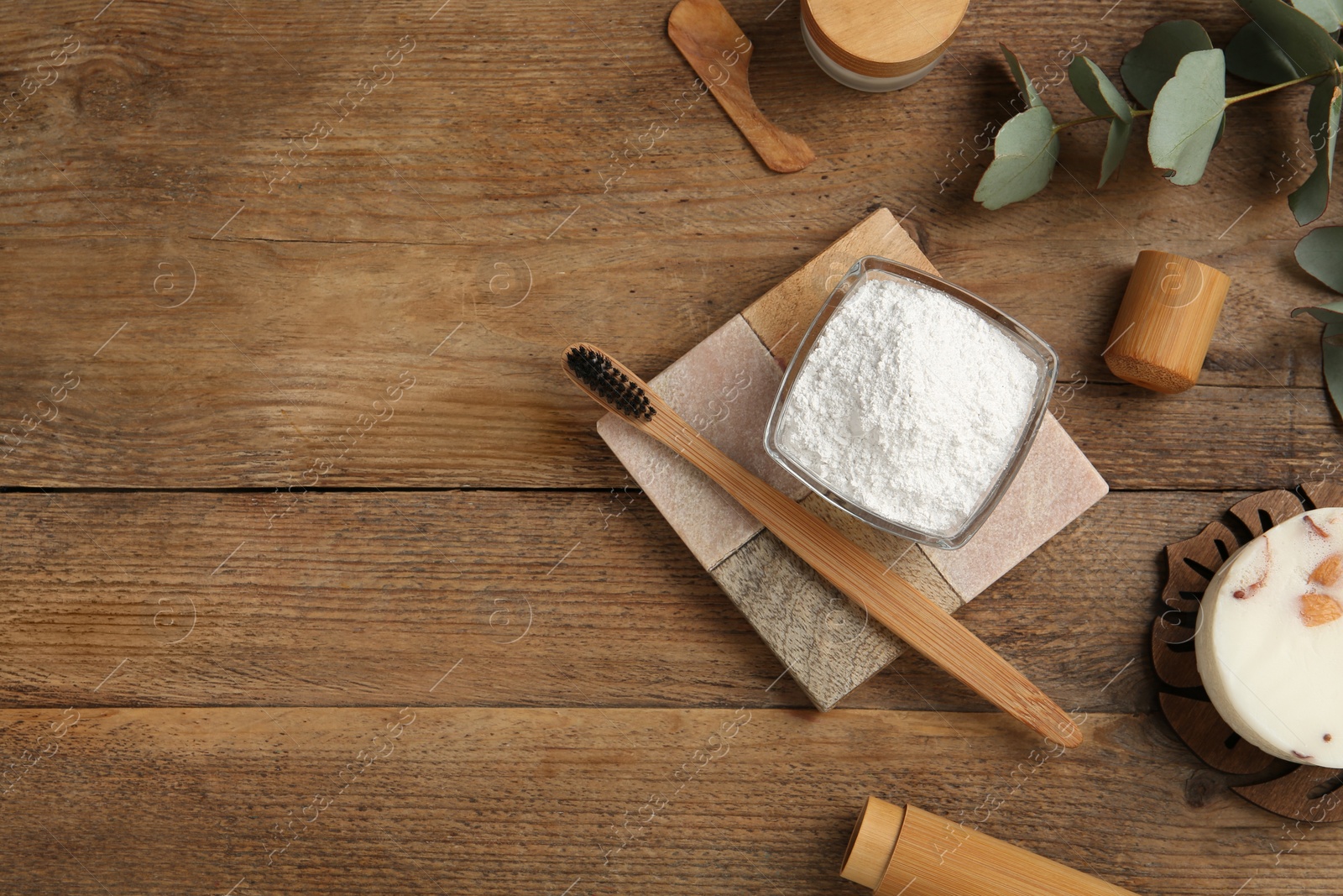 Photo of Flat lay composition with tooth powder and eucalyptus on wooden table, space for text