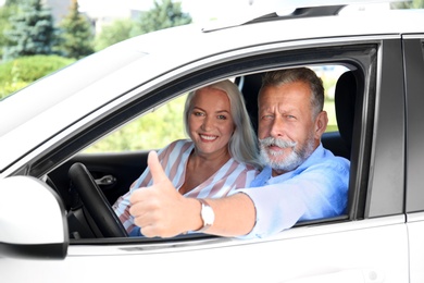 Happy senior couple travelling together in car