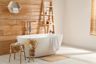 Photo of Bathroom interior with white tub and decor near wooden wall