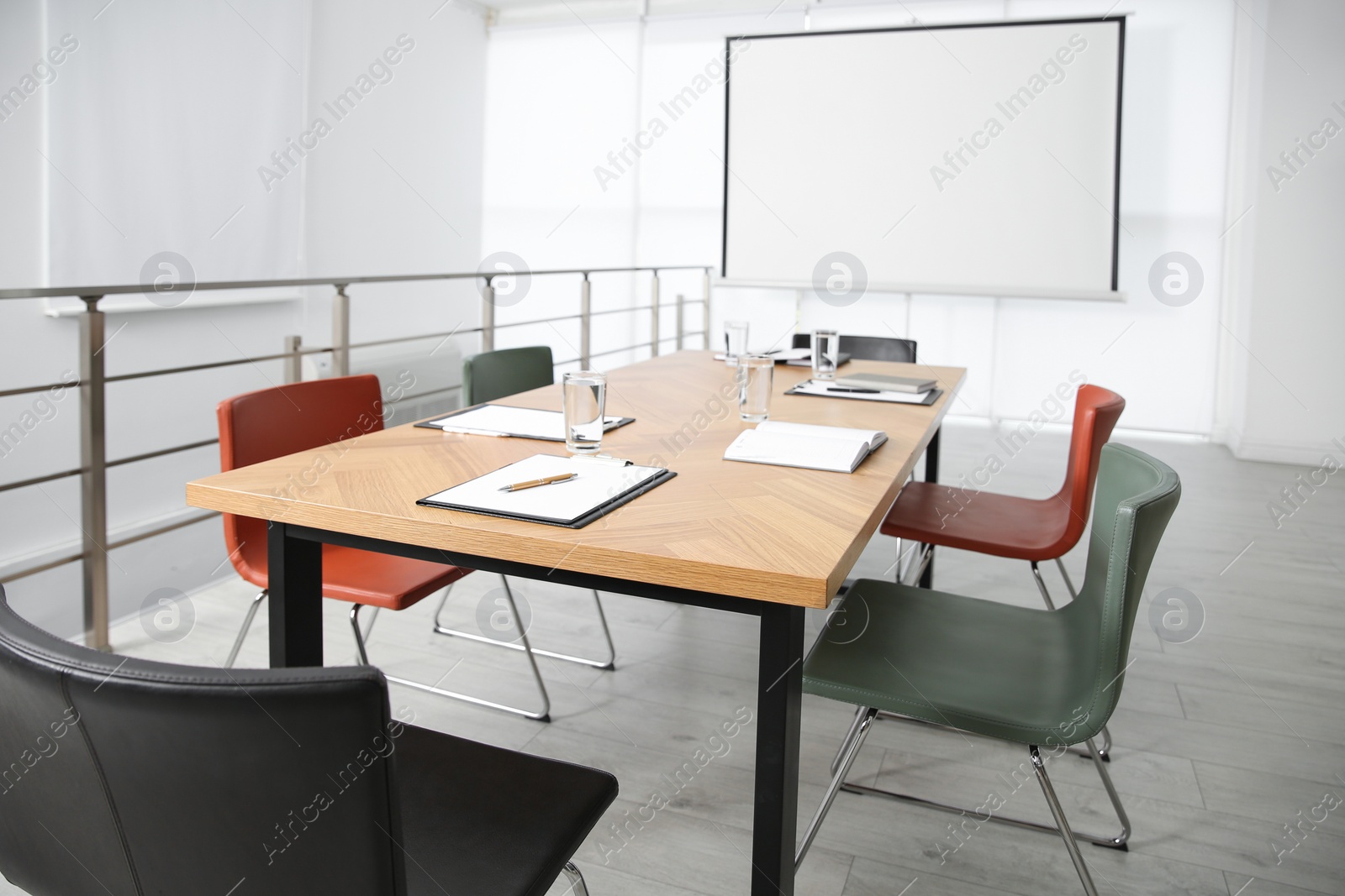 Photo of Modern meeting room interior with large table and projection screen