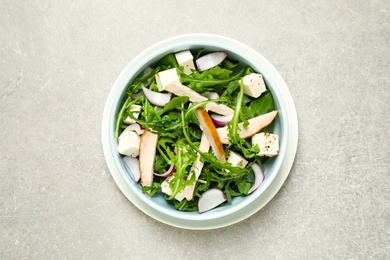Photo of Delicious salad with chicken, arugula and feta cheese on grey table, top view