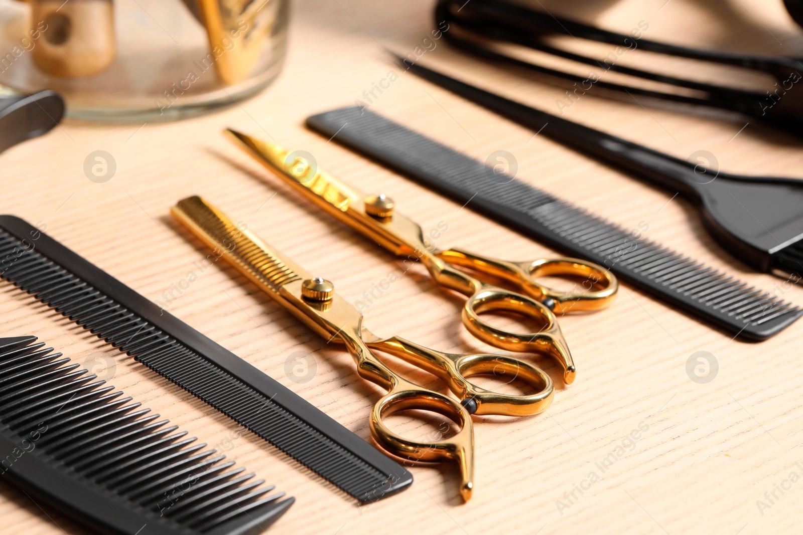 Photo of Hairdresser tools. Different scissors and combs on wooden table, closeup