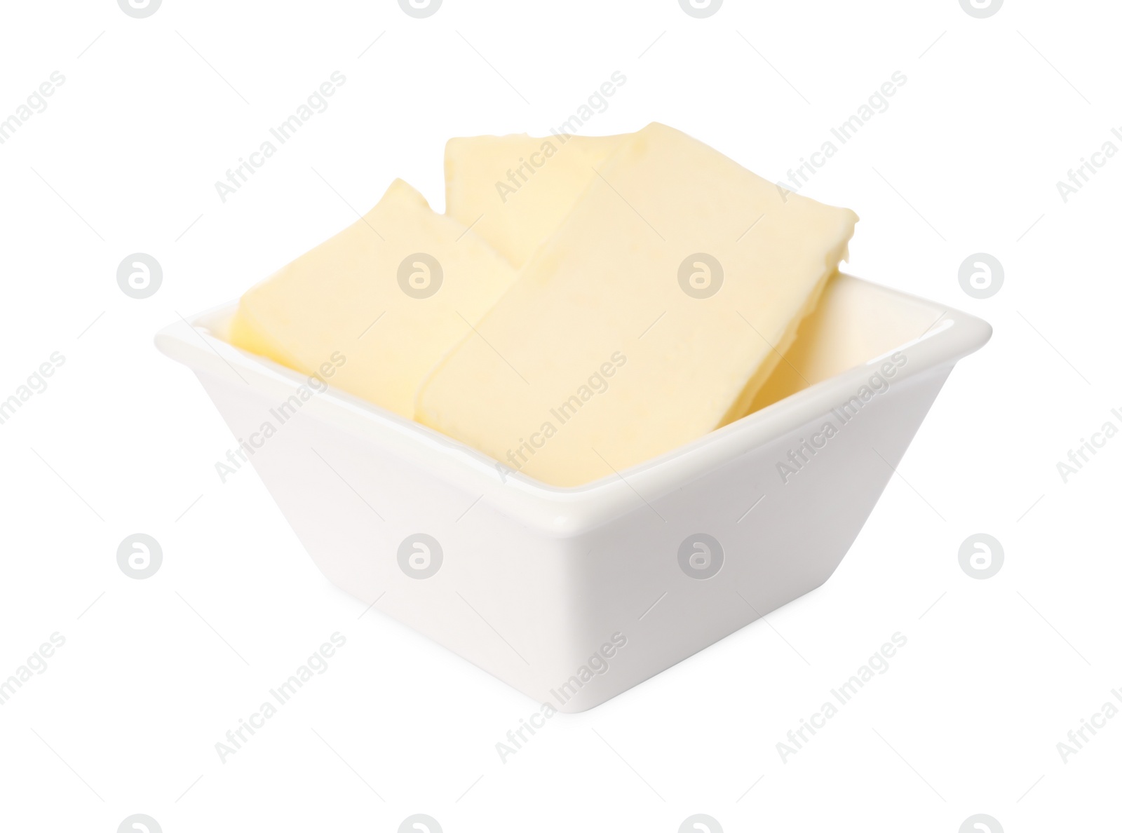 Photo of Tasty butter pieces in bowl isolated on white