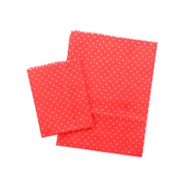 Red reusable beeswax food wraps on white background, top view