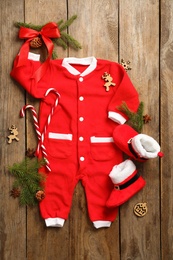 Photo of Flat lay composition with cute Christmas baby clothes on wooden background