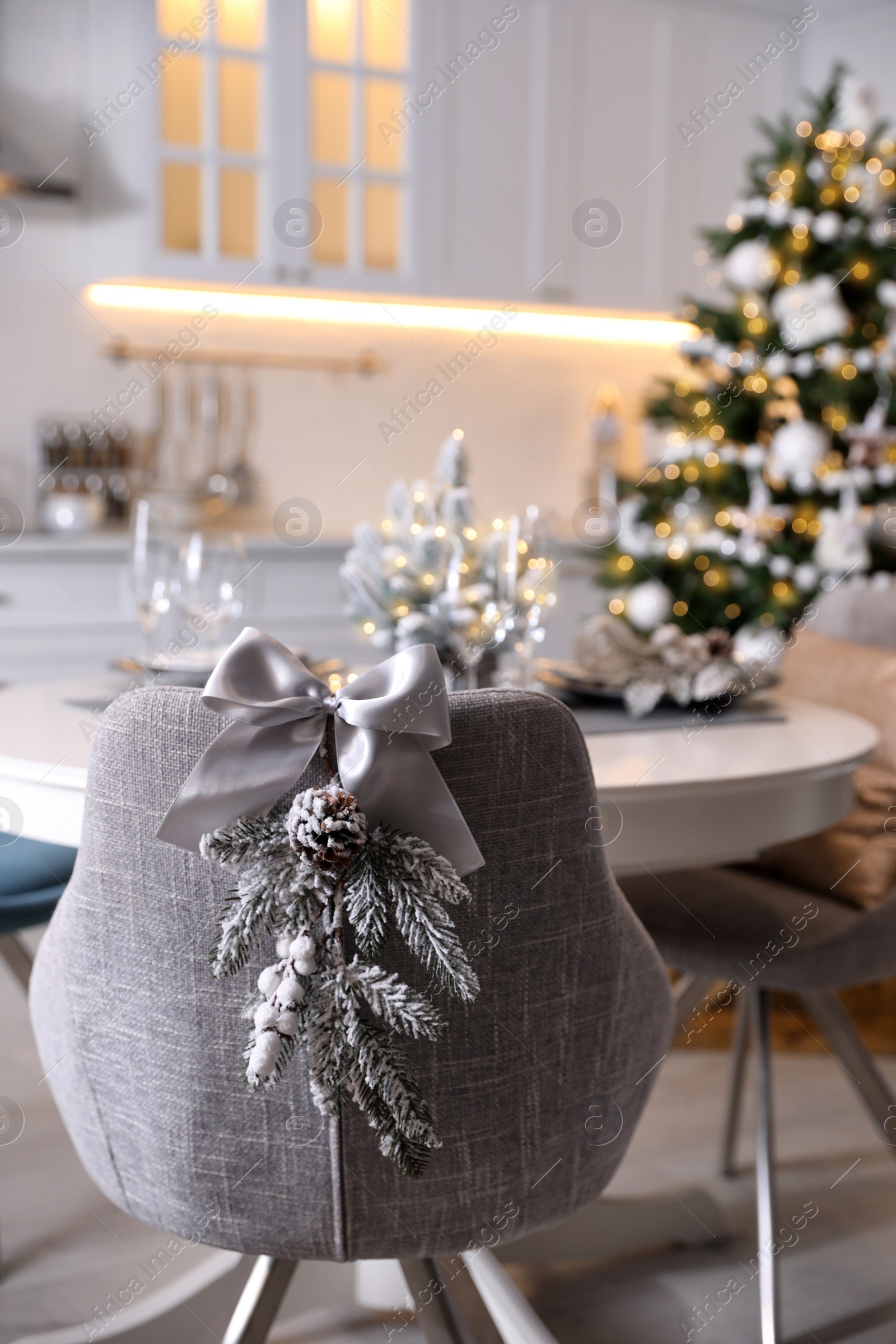 Photo of Grey chair with beautiful Christmas decor in kitchen. Interior design