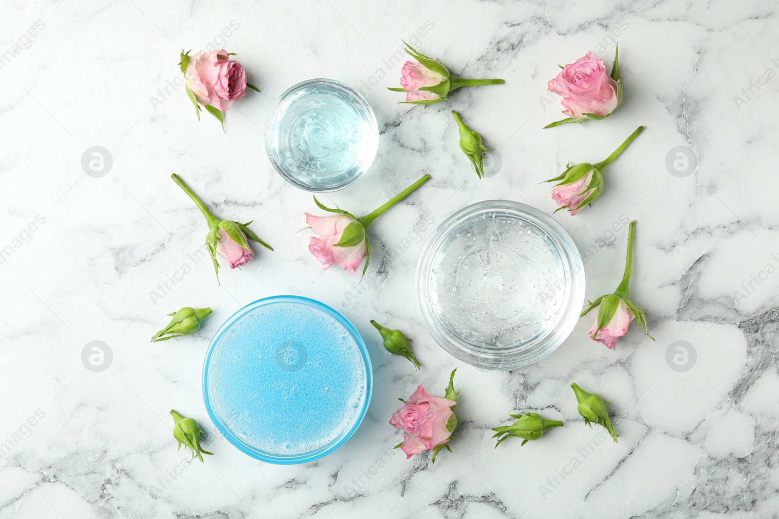 Photo of Flat lay composition with cosmetic gel and beautiful flowers on white marble table