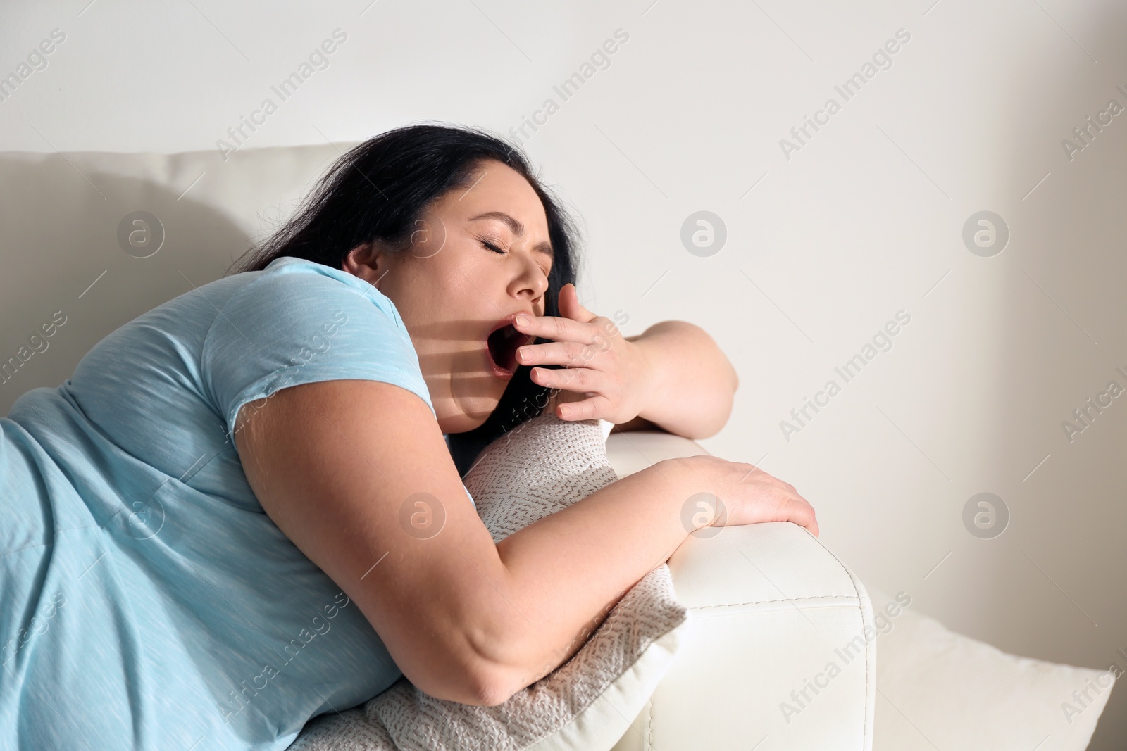 Photo of Lazy overweight woman resting on sofa at home