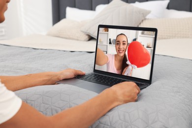 Long distance love. Man having video chat with his girlfriend via laptop at home, closeup