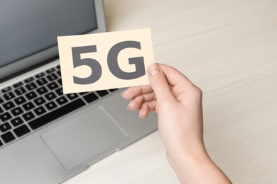 Photo of 5G technology, Internet concept. Woman holding card over laptop on table, closeup