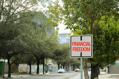Road sign with words Financial Freedom outdoors, space for text