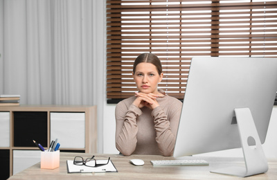 Photo of Professional psychotherapist at table with computer in modern office