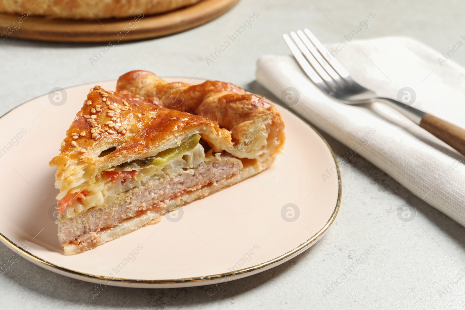 Photo of Piece of tasty homemade pie with filling on light grey table