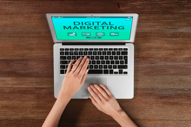 Digital marketing concept. Woman working with laptop at table, top view