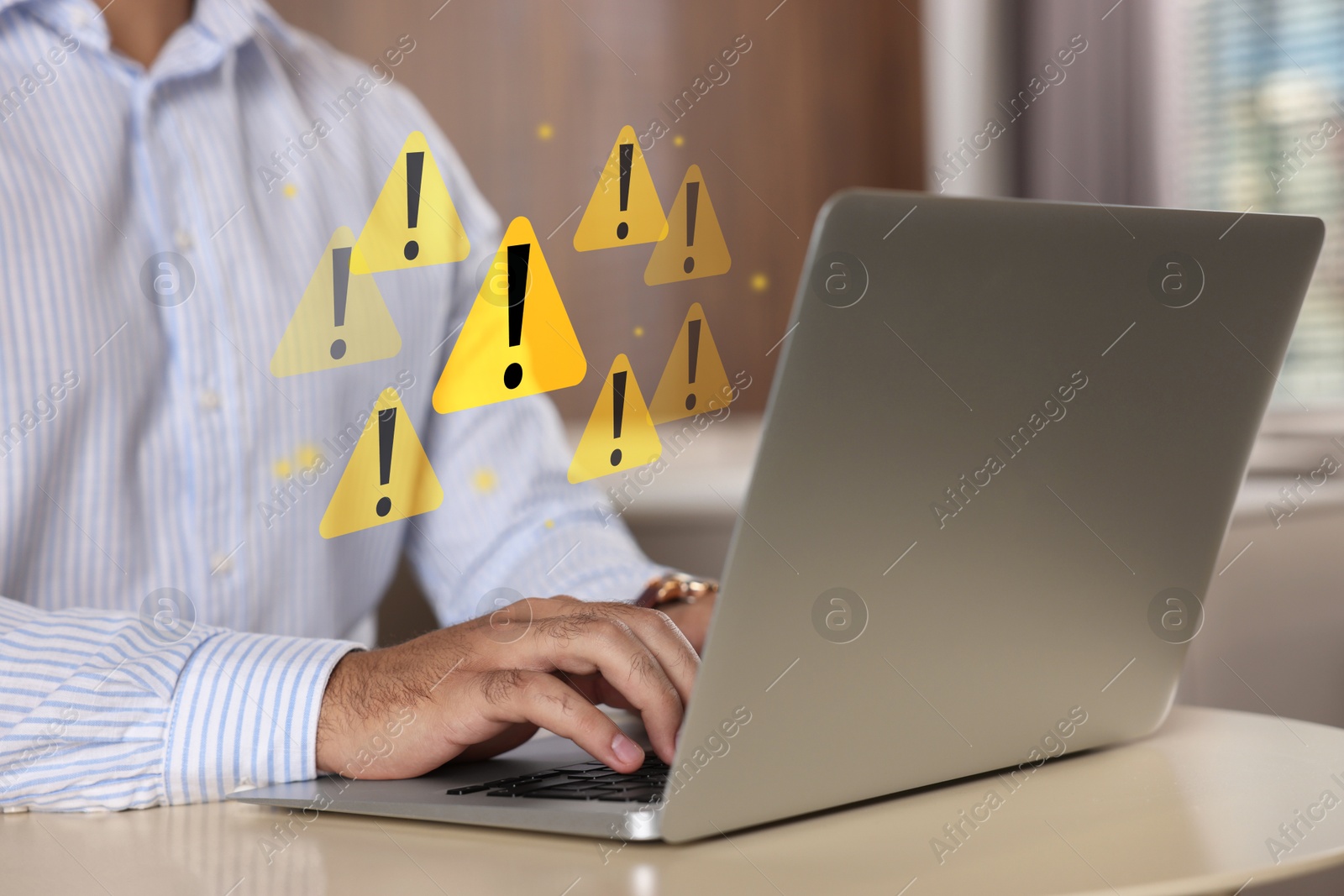 Image of Man using laptop at table, closeup. Warning signs for spam messages above device