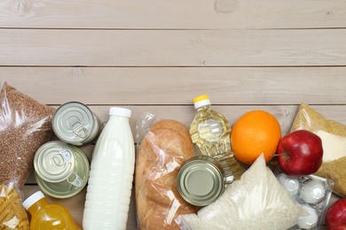 Photo of Different donation food on wooden table, flat lay. Space for text