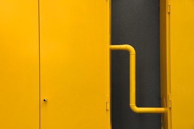 Photo of Yellow gas distribution cabinet near brown wall
