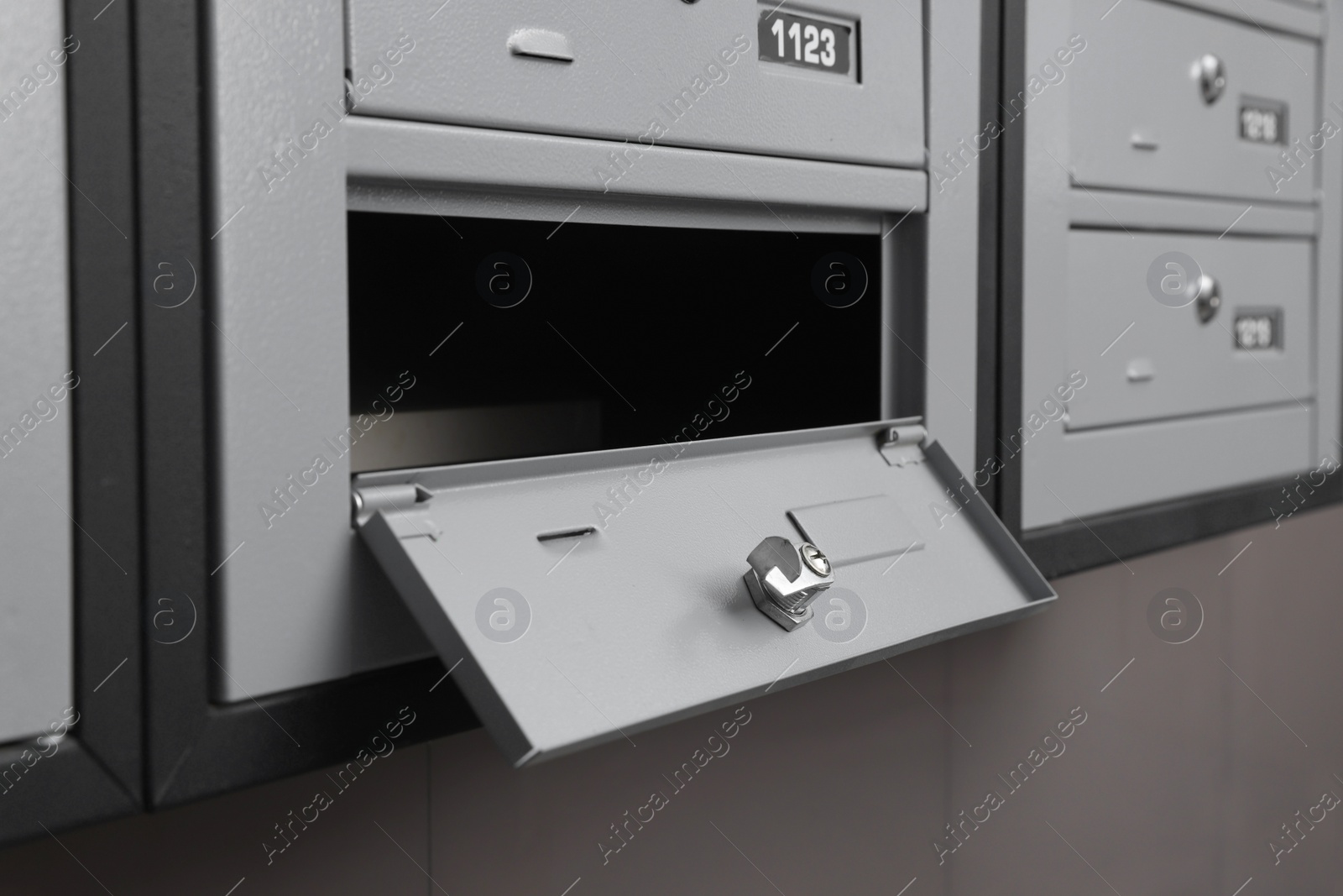 Photo of Open empty metal mailbox with keyhole indoors