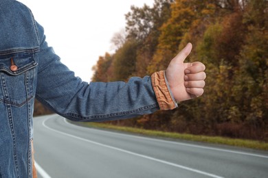 Image of Man catching car on road, closeup. Hitchhiking trip