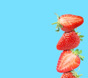 Image of Stack of fresh strawberries on light blue background, space for text