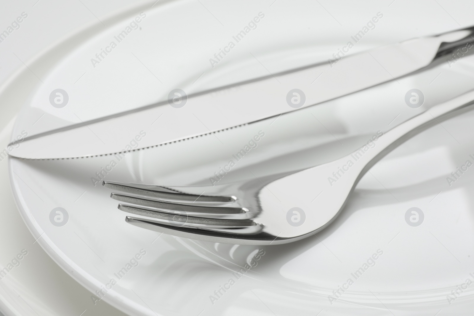 Photo of Clean plates, fork and knife, closeup view