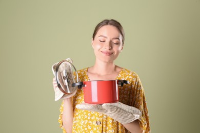 Happy woman with pot on olive background