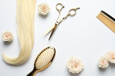 Photo of Flat lay composition with different hairdresser tools and flowers on white background, space for text