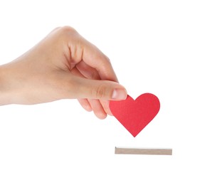 Photo of Woman putting red heart into slot of donation box against white background, closeup