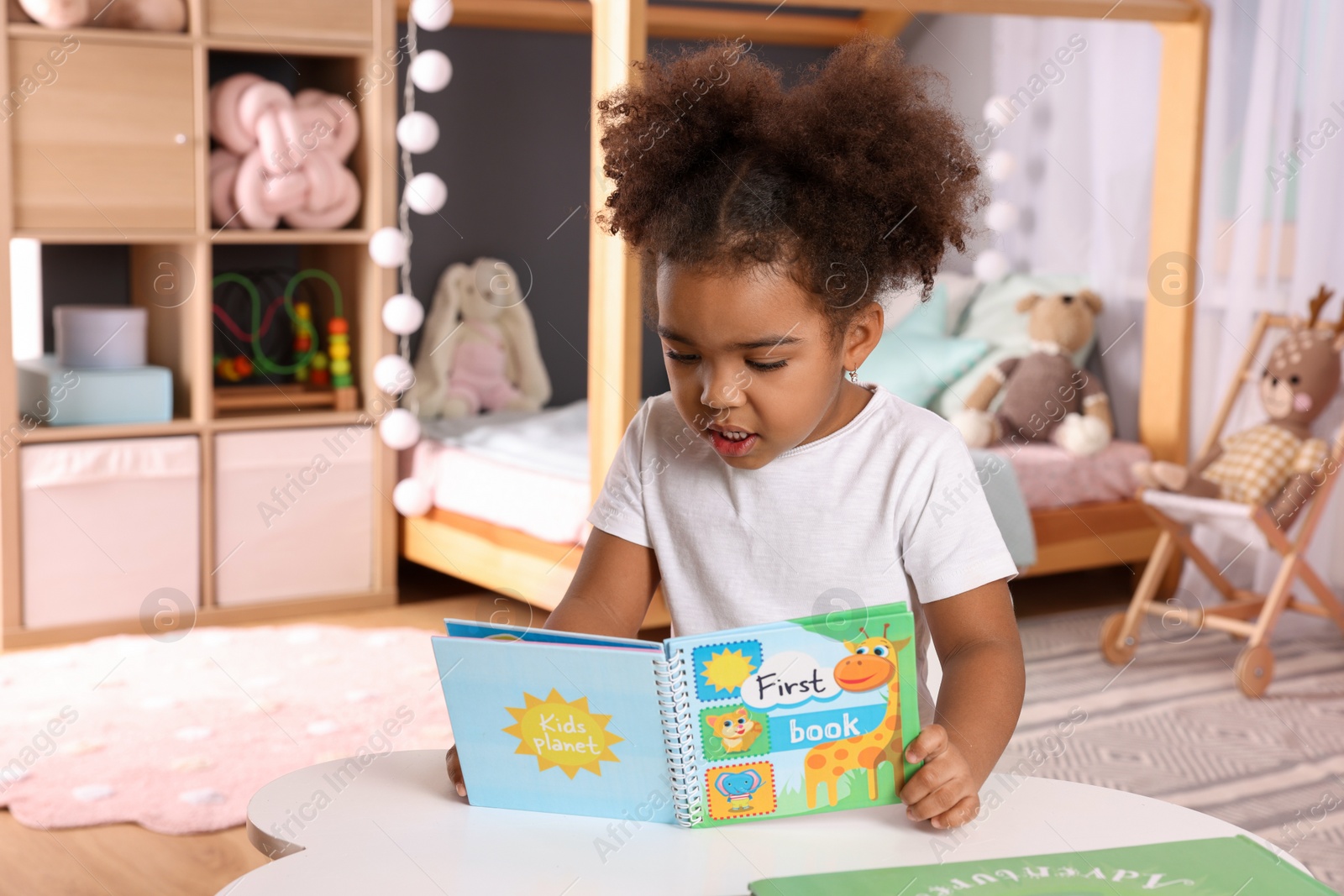 Photo of African American girl reading book at home