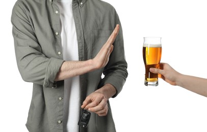 Man with car keys refusing alcohol while woman suggesting him beer on white background, closeup. Don't drink and drive concept