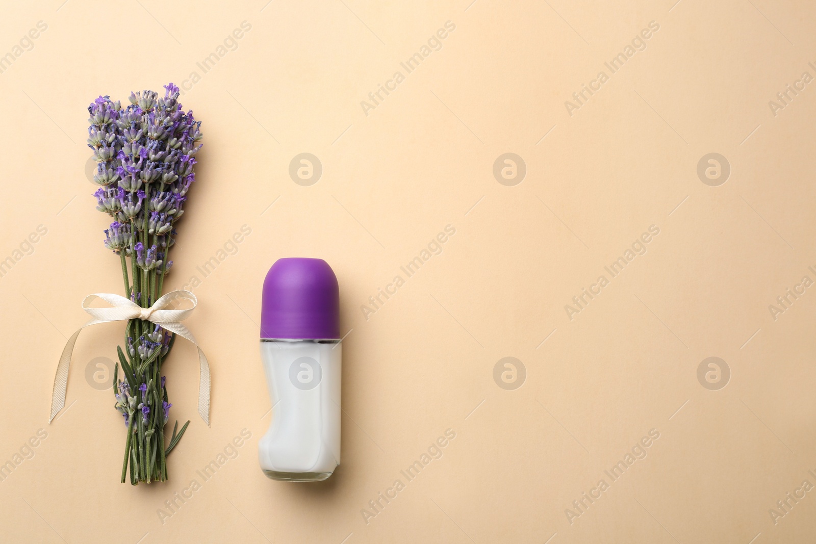 Photo of Female deodorant and lavender flowers on beige background, flat lay. Space for text