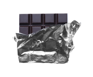 Photo of Delicious dark chocolate bar wrapped in foil isolated on white