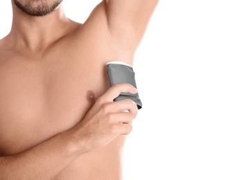 Young man using deodorant on white background, closeup. Space for text