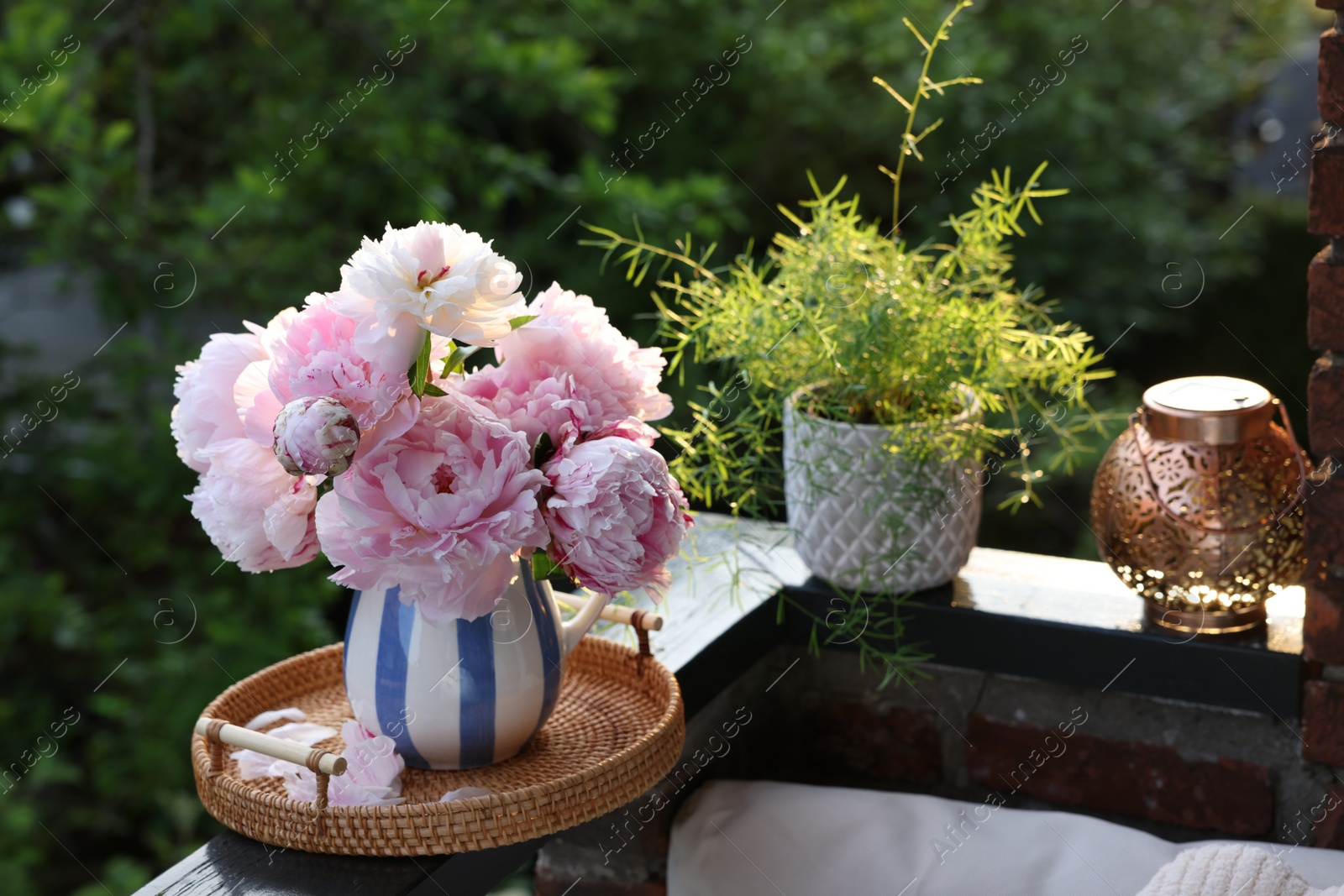 Photo of Beautiful pink peony flowers in vase on balcony railing outdoors