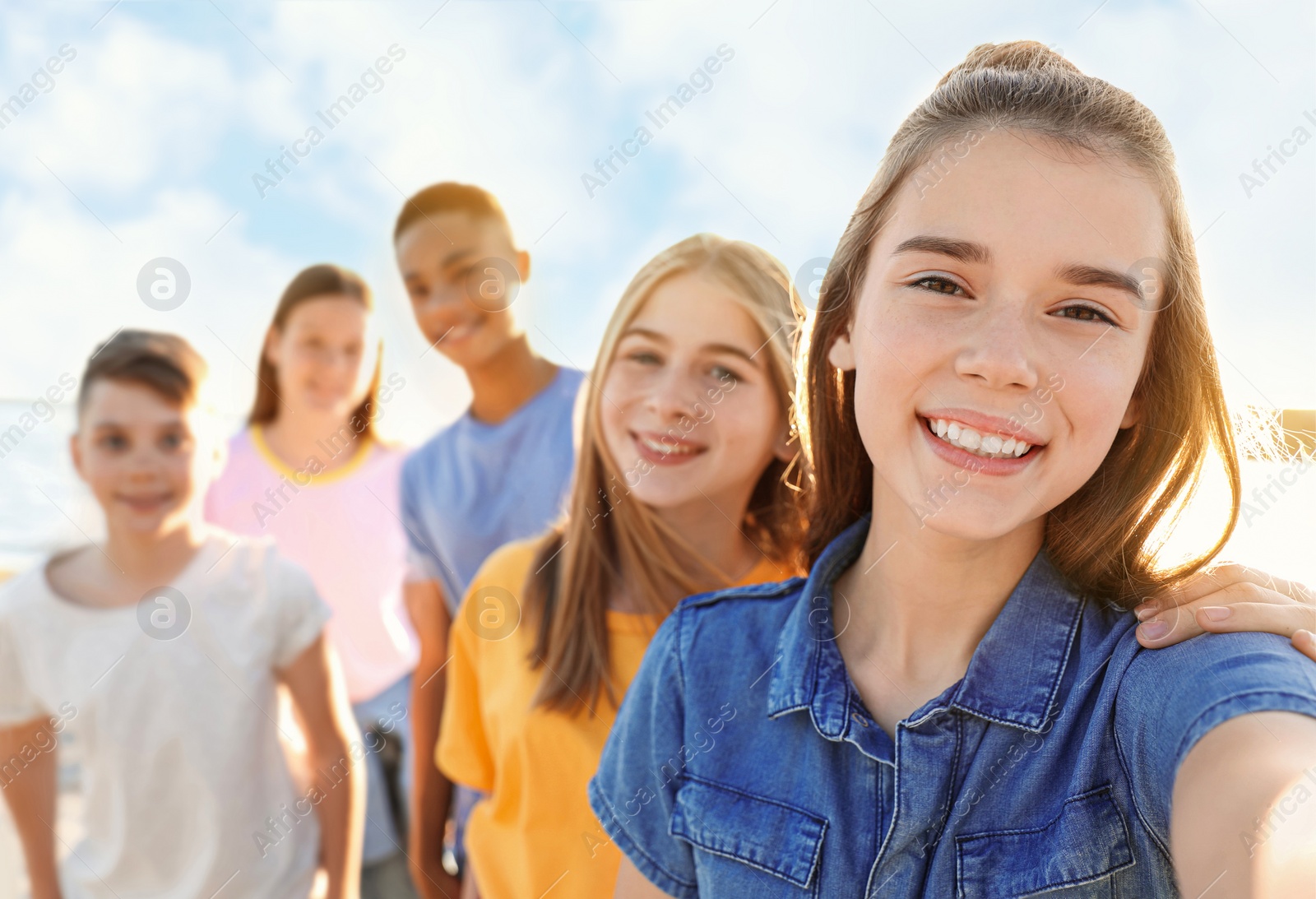 Image of School holidays. Group of happy children taking selfie outdoors