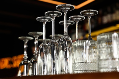 Photo of Different empty clean glasses on counter in bar, low angle view