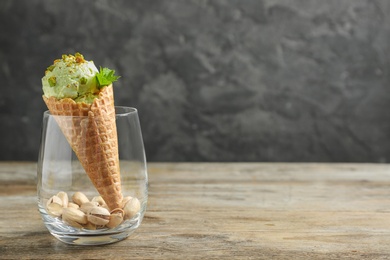 Delicious green ice cream served on wooden table. Space for text