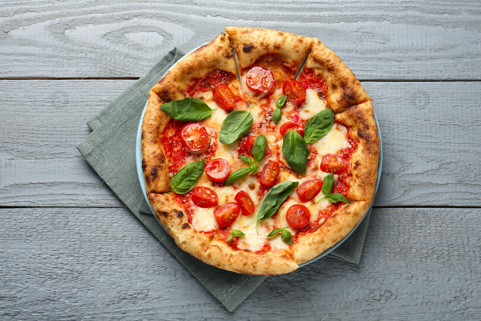 Photo of Delicious Margherita pizza on gray wooden table, top view