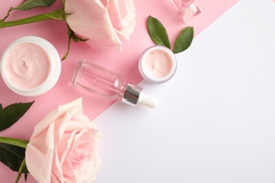 Photo of Flat lay composition with rose essential oil on color background, space for text