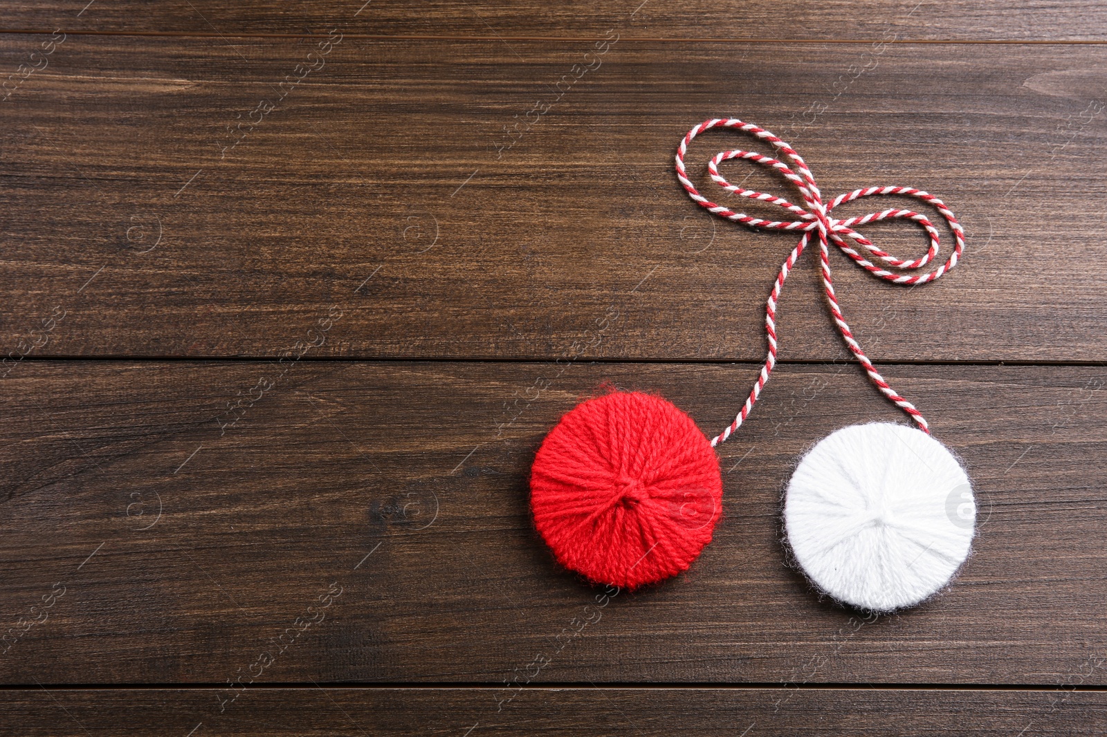 Photo of Traditional martisor on wooden background, top view with space for text. Beginning of spring celebration