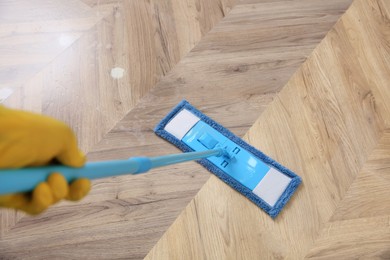 Image of Janitor cleaning parquet floor with mop, closeup. Difference before and after cleaning