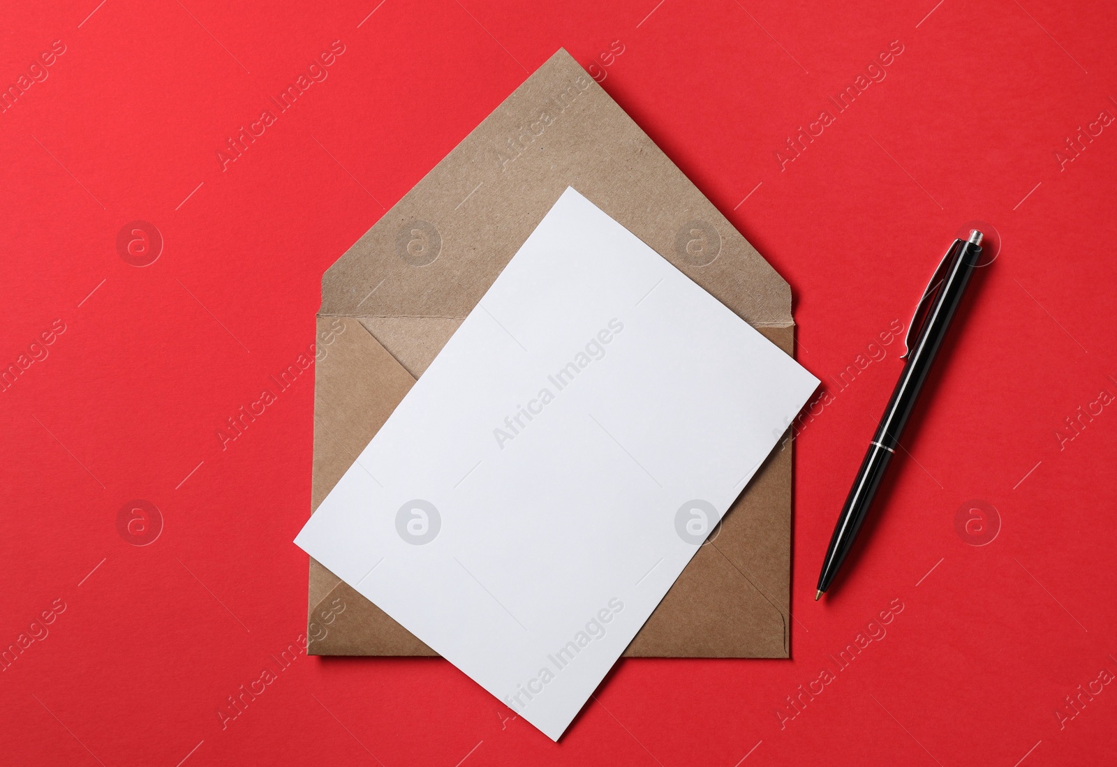 Photo of Blank sheet of paper, letter envelope and pen on red background, top view. Space for text