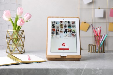 MYKOLAIV, UKRAINE - APRIL 12, 2021: iPad with Pinterest app on grey marble table in office