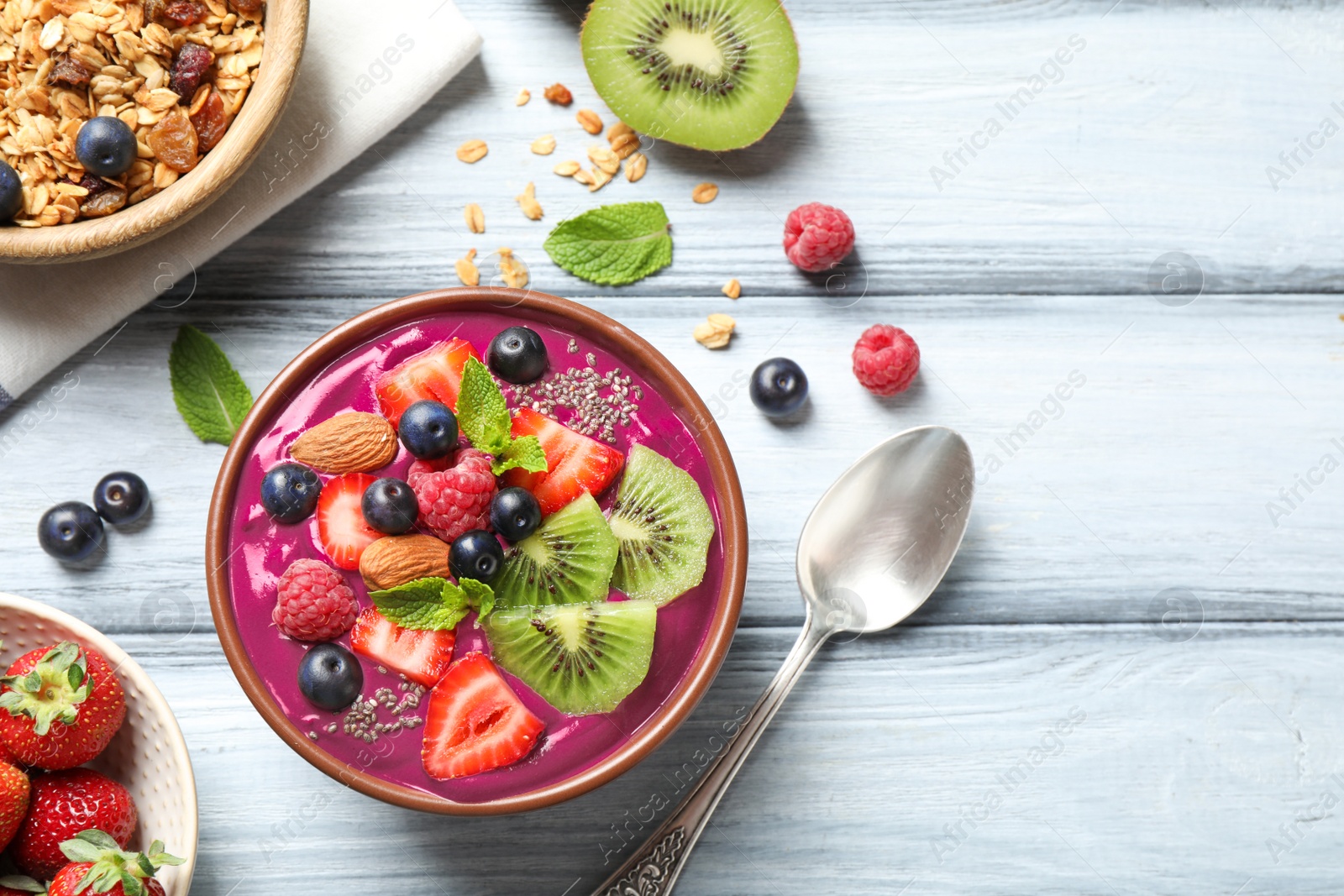 Photo of Delicious acai smoothie with chia seeds and fruits served on white wooden table, flat lay. Space for text