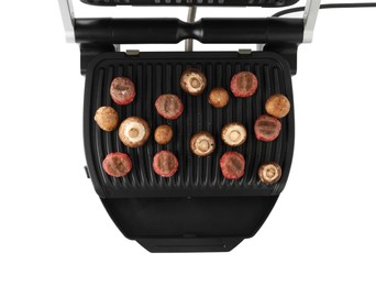 Electric grill with meat balls and mushrooms isolated on white, top view