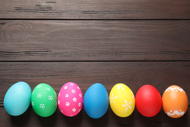 Photo of Colorful Easter eggs on wooden background, flat lay. Space for text