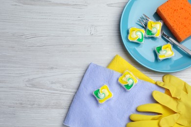 Photo of Flat lay composition with dishwasher detergent pods and tablets on white wooden table, space for text