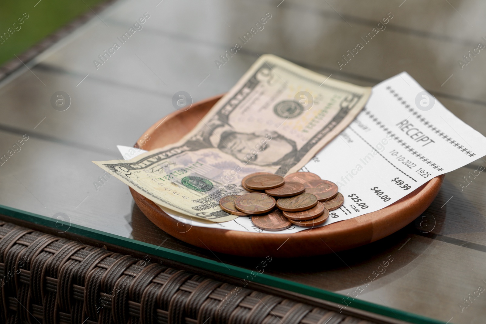 Photo of Tips and receipt on wooden table, closeup